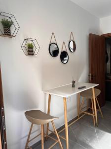a table and two chairs next to a wall with mirrors at Maria's Apartment 2 in Galata