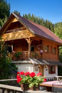 una casa de madera con flores delante en Shepherds House "Alpine Dreams", en Solčava