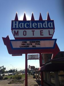 a sign for a margarida motel in a parking lot at Hacienda Motel in Yuma