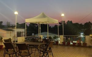 a table with chairs and an umbrella on a patio at Solitude, The Boutique Hotel in Haldwāni