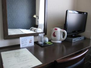 a desk with a computer and a monitor and a mirror at Toyohashi Station Hotel / Vacation STAY 66965 in Toyohashi