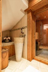 Luxury Avoriaz Chalet with hot tub في أفورياز: حمام مع دش ومرحاض وحوض استحمام