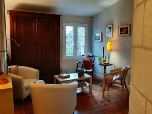 un soggiorno con tavolo e sedie di L'ESCALE DE BEL AIR Chambres d'hôtes a Gauriac