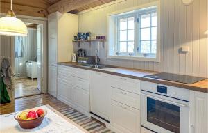 a kitchen with white cabinets and a bowl of fruit at Beautiful Home In Kvam With House A Mountain View in Kvam