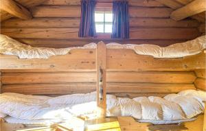 een groot bed in een blokhut met een raam bij Beautiful Home In Kvam With House A Mountain View in Kvam