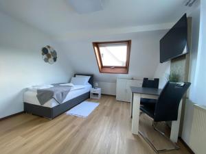 - une chambre avec un lit, un bureau et une table dans l'établissement Apartment Q im Zentrum von Königsbronn, à Königsbronn
