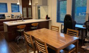 a kitchen with a wooden table and chairs and a sink at Avanti Chalet Hakuba in Hakuba
