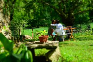 a woman standing next to a table in a garden at Gîte La Source in Grusse