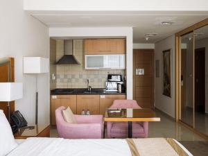 a room with a bed and a table and a kitchen at Belle Vue Building in Dubai