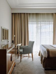 杜拜的住宿－Belle Vue Building，酒店客房配有一张床、一把椅子和一台电视。