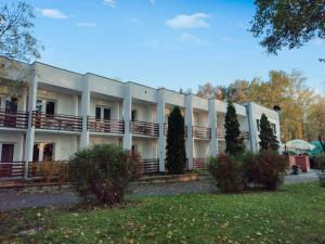 un gran edificio blanco con árboles delante de él en Motel Strzeszynek, en Poznan