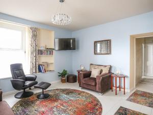 salon z kanapą, krzesłami i telewizorem w obiekcie Gadlys House 62 w mieście Beaumaris