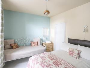 um quarto com 2 camas e um sofá em Gadlys House 62 em Beaumaris