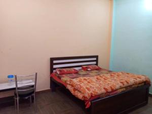 a bedroom with a bed and a table and a chair at Hotel Shree Ganesh, Jhansi in Jhānsi