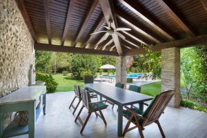 een patio met een tafel en stoelen en een plafondventilator bij Villa Oleandra with Pool up to 12 People in Volta Mantovana