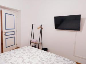 a bedroom with a bed and a flat screen tv on the wall at Brignole B in Genoa