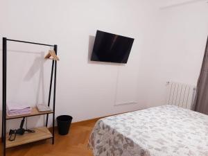 a bedroom with a bed and a television on a wall at Brignole B in Genoa