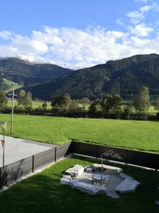 un patio trasero con una hoguera en el césped en Alpen Chalet Bramberg, en Bramberg am Wildkogel