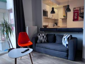 a living room with a couch and a red chair at Airport Apartment Warszawa in Warsaw