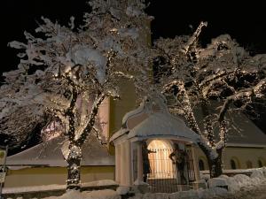 a gazebo with snow covered trees in front of a building at Hotel Garni Central - Zimmer - Studios - Apartments in Kappl