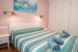 a bedroom with a bed with blue towels on it at Seafront L'Estartit Apartments in L'Estartit