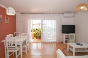 a living room with a table and a tv at Seafront L'Estartit Apartments in L'Estartit
