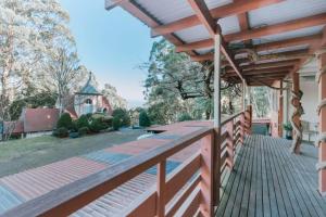 a porch with a wooden fence and a house at Olinda Nature Retreat 4 Bed 3Bth House Fire, Bath in Olinda
