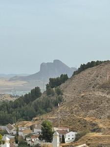 a town on a hill with a mountain in the background at Despertar in Antequera
