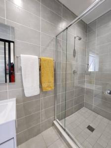 y baño con ducha y toalla amarilla. en Ballito Hills Lifestyle Estate Unit 423 en Ballito