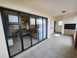 a large room with glass windows and a television at Ballito Hills Lifestyle Estate Unit 423 in Ballito