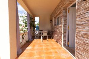 um quarto com uma varanda com uma mesa e cadeiras em INNOUTHOME Villa privada familiar con piscina rovelló em L'Ametlla de Mar