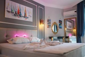 アランヤにあるPolat tatil evleriのベッドルーム1室(ピンクの照明が付いた大型ベッド1台付)