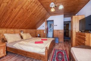 a bedroom with a bed and a wooden ceiling at Penzion Šilon in Ždiar