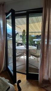 una puerta de cristal que da a un patio con mesa y sillas en LAnJA ihr besonderes Urlaubszuhause, en Lagundo
