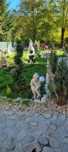 a statue of a dog holding a frisbee in a garden at Tiny Dream House in Buşteni