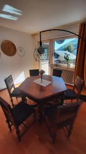 une table à manger avec des chaises et une grande fenêtre dans l'établissement LAnJA ihr besonderes Urlaubszuhause, à Lagundo