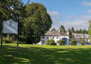 una señal frente a una gran casa blanca en Gretna Hall Hotel, en Gretna Green