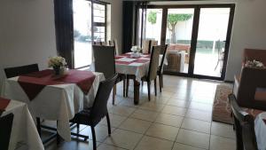 uma sala de jantar com mesas e cadeiras com vista para um pátio em 47 On Preston Guesthouse em Joanesburgo