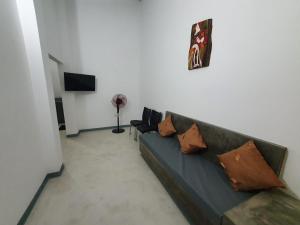 a living room with a couch with pillows on it at The Anchorage Holiday Apartments - Negombo in Negombo