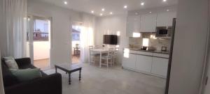 eine Küche und ein Wohnzimmer mit einem Sofa und einem Tisch in der Unterkunft Precioso apartamento en el corazon de la cala. in Mijas Costa