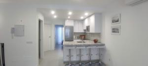 a white kitchen with a sink and a counter at Piso en el Centro de La Cala in Mijas Costa