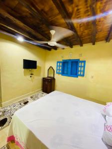 a bedroom with a large bed and a blue window at خزفستا Khazfista in ‘Izbat an Nāmūs