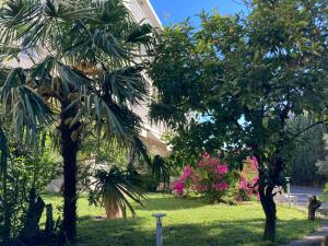 un cortile con alberi e fiori di fronte a un edificio di Hotel Ghironi a La Spezia