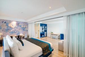 a bedroom with a large bed and a dining room at Bhukitta Boutique Hotel Phuket Town in Phuket