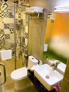 uma casa de banho com um lavatório, um WC e um espelho. em Ipeace Hotel - Bùi Viện Walking Street em Ho Chi Minh