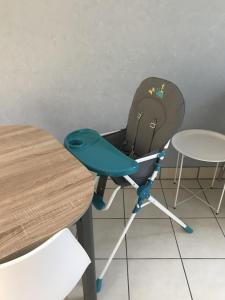 une chaise pour enfant assise à côté d'une table dans l'établissement Maison au bord du Loir, à La Flèche