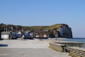 a view of a beach with blue buildings and the ocean at Les bords du lac in Cany-Barville