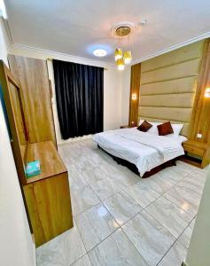 a bedroom with a bed and a dresser in it at الرموز الصادقة للشقق المخدومة Apartments alrumuz alsadiqah in Jeddah