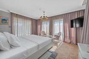 ein Schlafzimmer mit einem großen weißen Bett und einem Tisch in der Unterkunft Villa Carolus-Luxurious Dalmatia Villa in Vodice