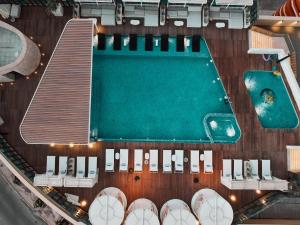 an overhead view of a swimming pool and some chairs at The House Hotel Al Khiran in Al Khīrān